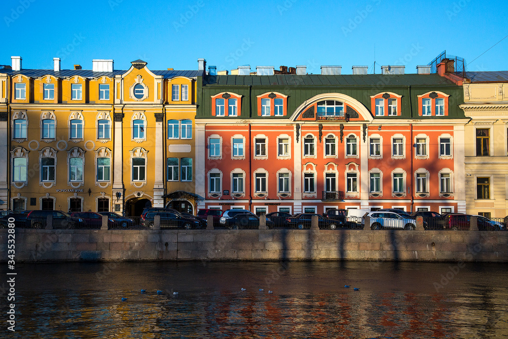Old buildings on the embankment of St. Petersburg. Parked cars along the embankment.