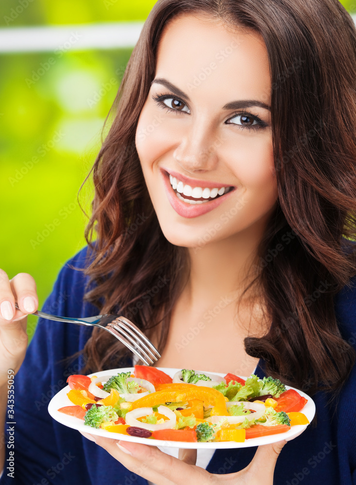 Portrait picture of happy smiling young brunette woman with vegetarian vegetable salad Portrait picture of happy smiling young brunette woman with vegetarian vegetable salad