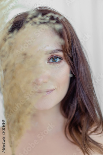 Pretty girl with long brunette hair is covered her face to spiklet photo