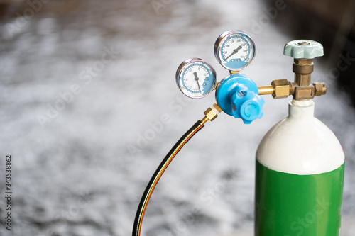 Equipment medical Oxygen tank and Cylinder Regulator gauge.Control pressure oxygen gas for care a patient respiratory disease and emergency CPR at Hospital.Close up focus on fish pond background. © Poh Smith