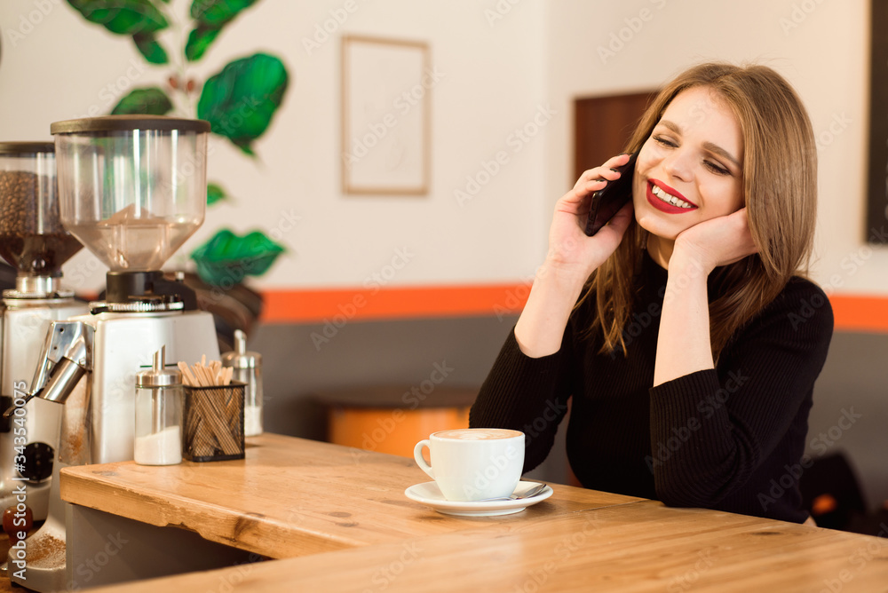 happy Caucasian female watching her photo on cell telephone while relaxing in cafe. happy Caucasian female watching her photo on cell telephone while relaxing in cafe.