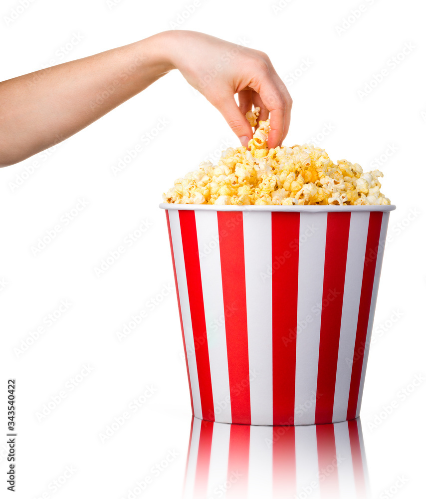 Woman hand picking popcorn from striped bucket isolated on white background Woman hand picking popcorn from striped bucket isolated on white background