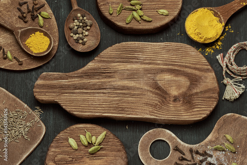 Spices on wooden cutting boards of different shapes on a dark background. photo