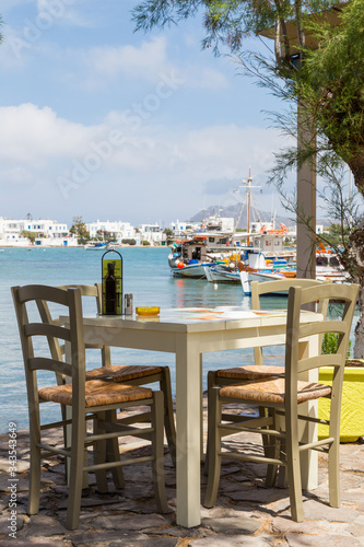 Fototapeta Naklejka Na Ścianę i Meble -  Restaurant table with boats on the background in a mediterranean island