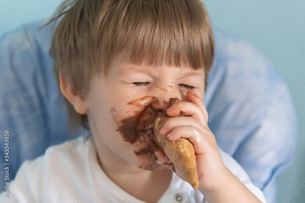 Little boy with chocolate ice cream smeared on face. Little boy eating ice cream