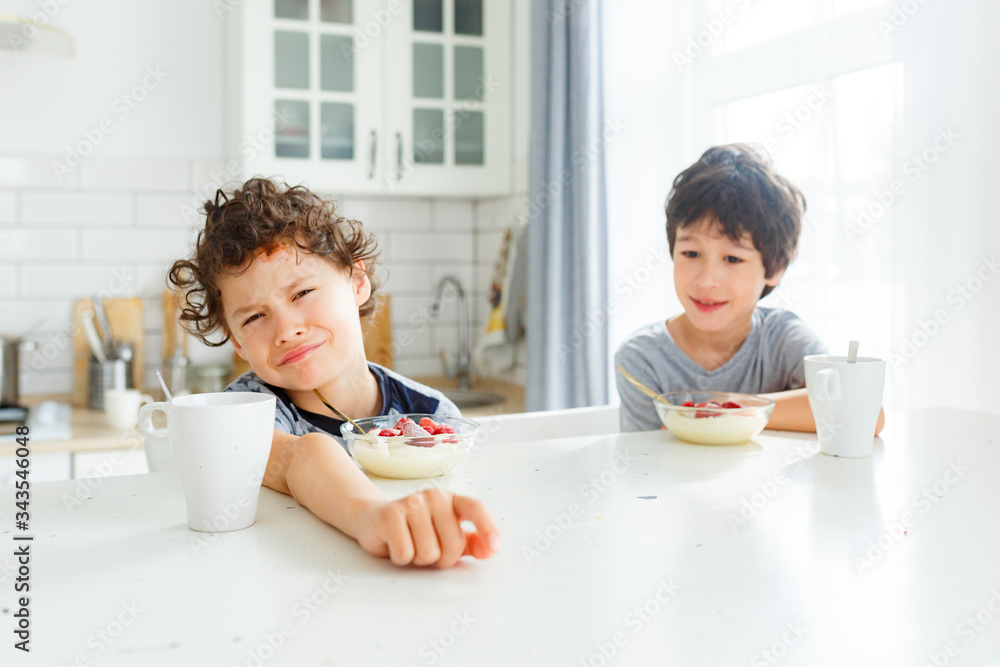 eal brothers have breakfast in the morning in a bright Scandinavian style kitchen with porridge with strawberries eal brothers have breakfast in the morning in a bright Scandinavian style kitchen with porridge with strawberries