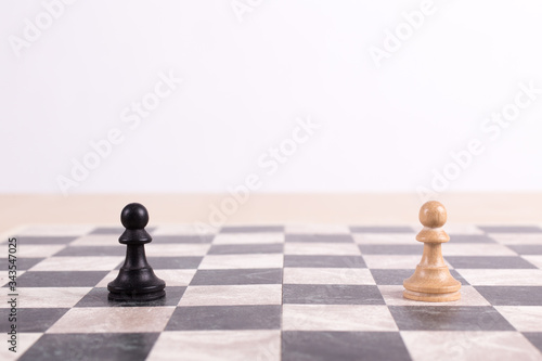 Close up side view of chess board with black pawn facing white pawn