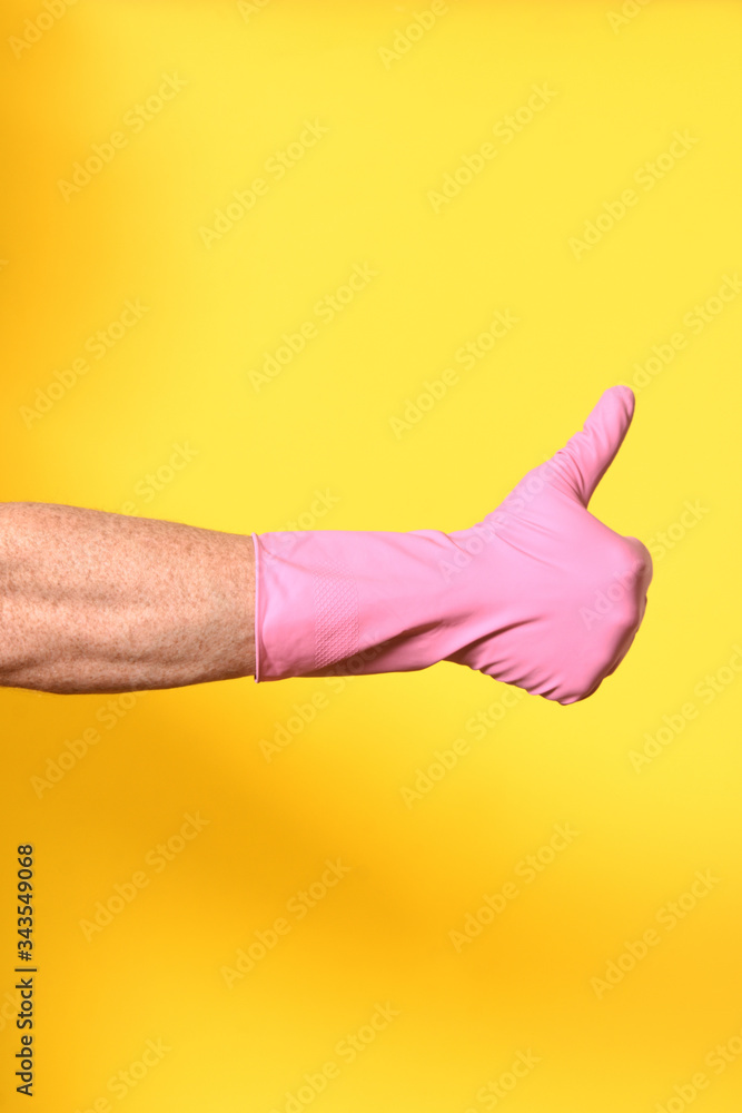 hand with glove and thumbs up on yellow background