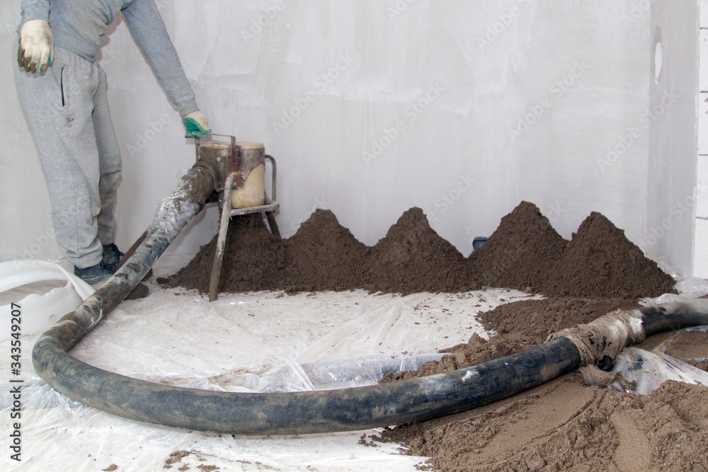 Screed Application Methods Machine running screed flooring. Worker at construction site sand and ...