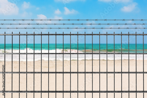Quarantine due to Novel Coronavirus COVID-19 2019 n-CoV Concept. Metal Fence with Barbed Wire in front of Sand Ocean Beach. 3d Rendering
