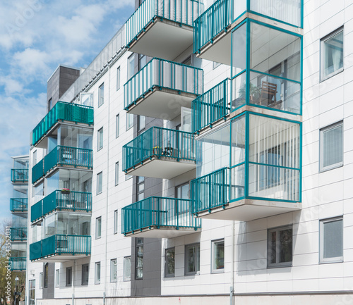 Hisingen, Newly built housing in apartment buildings, white facade with green balconies. The sun shines and shadows are formed on the facade
