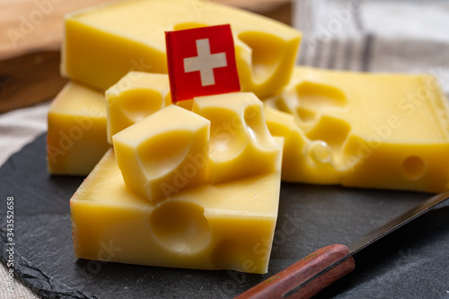 Foto Block of Swiss medium-hard yellow cheese emmental or emmentaler with round holes