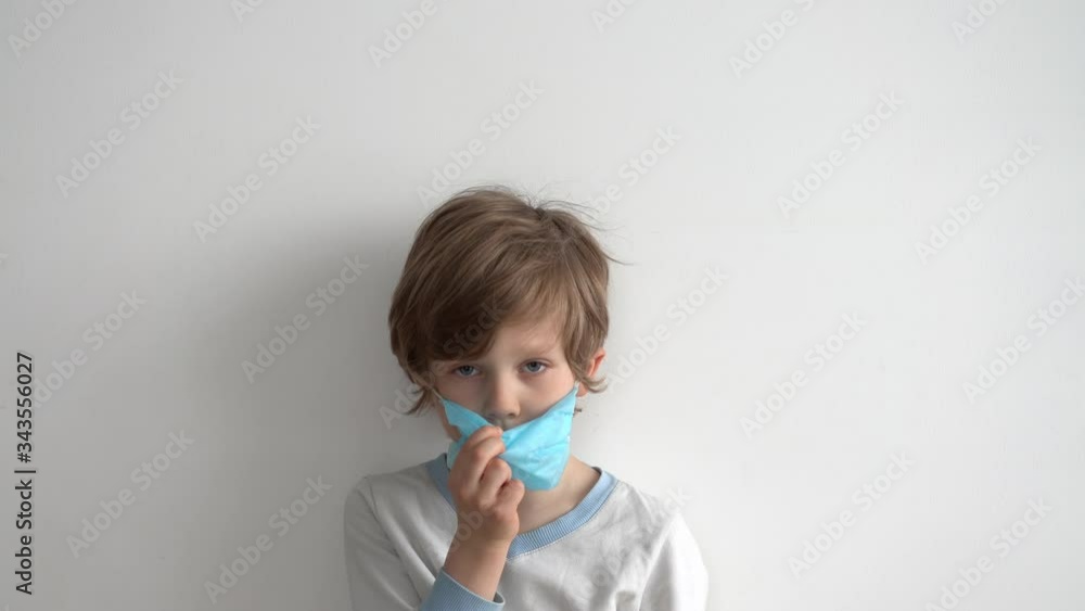 protection against coronavirus. little boy puts a mask on her face. protection against coronavirus. little boy puts a mask on her face.