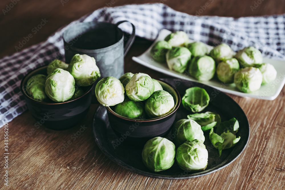 Choux de Bruxelles dans un petit bol céramique posé sur la table en bois en cuisine Choux de Bruxelles dans un petit bol céramique posé sur la table en bois en cuisine