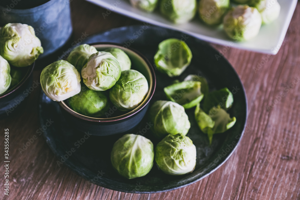 Choux de Bruxelles dans un petit bol céramique posé sur la table en bois en cuisine Choux de Bruxelles dans un petit bol céramique posé sur la table en bois en cuisine