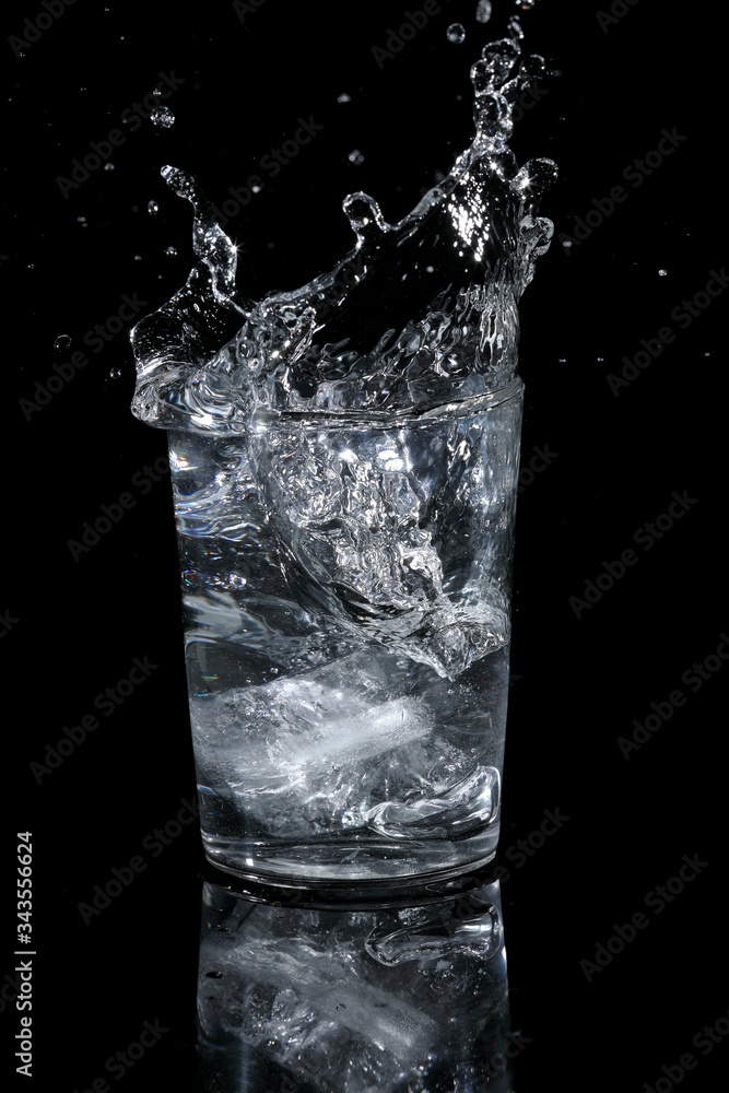 Ice falling into a glass and splashing Ice falling into a glass and splashing