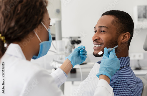 Fotografía Young african guy smiling to his female dentist