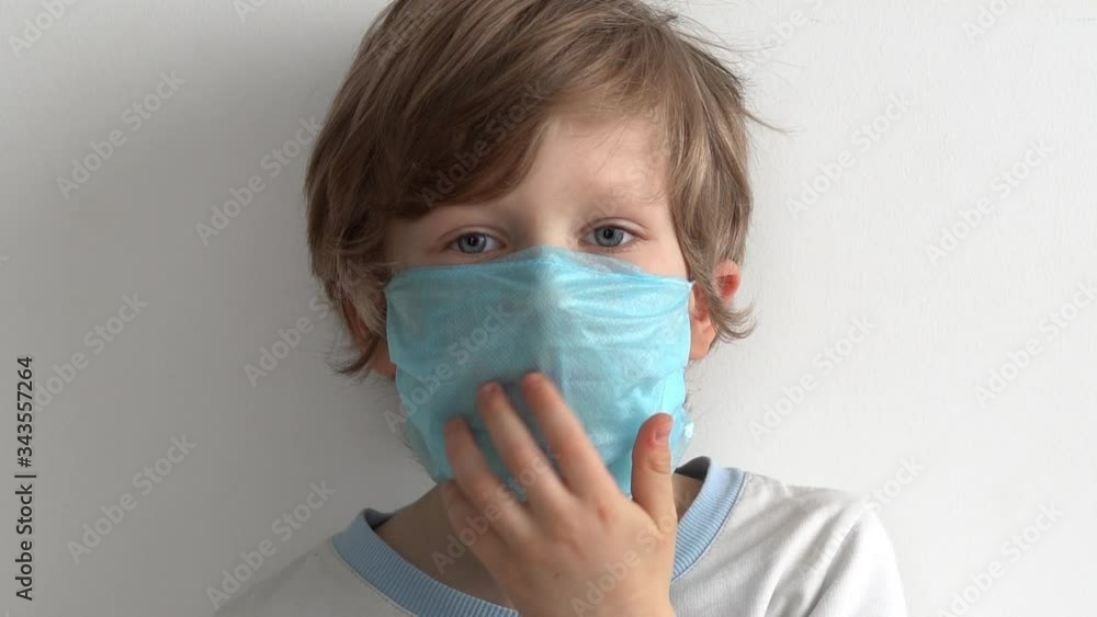 protection against coronavirus. little boy puts a mask on her face. protection against coronavirus. little boy puts a mask on her face.