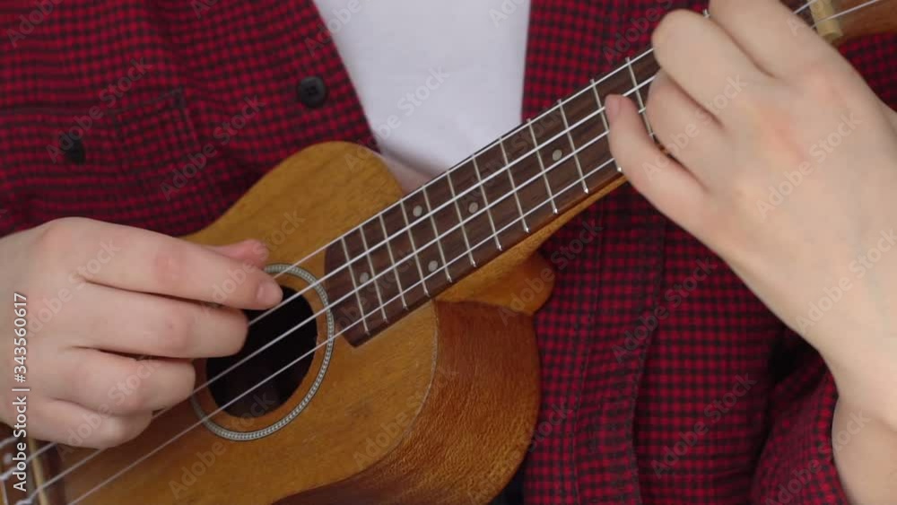 A woman plays the ukulele in the summer. Epidemic, coronavirus, COVID-19 A woman plays the ukulele in the summer. Epidemic, coronavirus, COVID-19