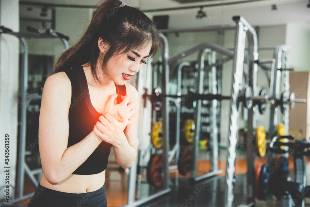 Fototapeta premium Young Asian girl having heart attack failure symptom. Healthcare and medical wellness of overworked and less sleeping. People lifestyle concept. Overdo work without break and workaholic illness theme