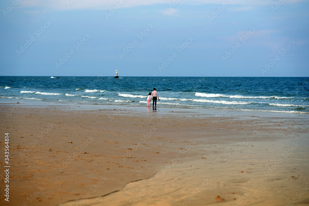 people stand on beach front at coast line on blue sky background people stand on beach front at coast line on blue sky background