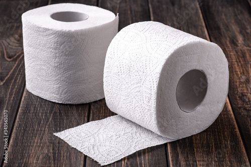 A roll of toilet paper on a wooden background.