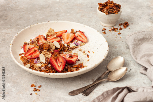 Tasty breakfast with yogurt, berries and granola on gray table