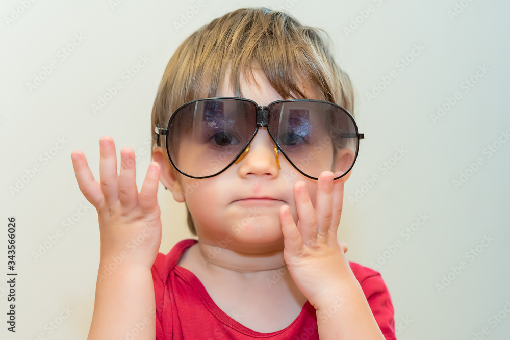 Little boy with big sunglasses. Close up face shot portrait of cute boy wearing huge over sized sun glasses Little boy with big sunglasses. Close up face shot portrait of cute boy wearing huge over sized sun glasses