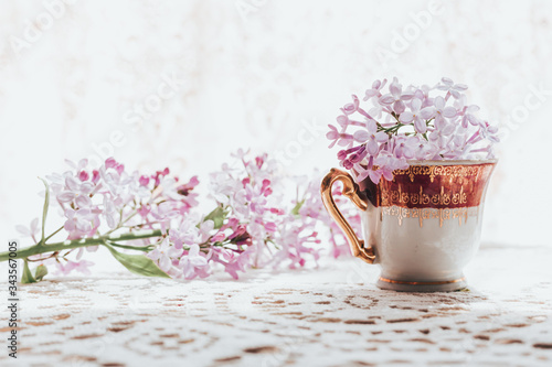 Retro tea cup with lilac flowers in it. Home decoration. Springtime vibes