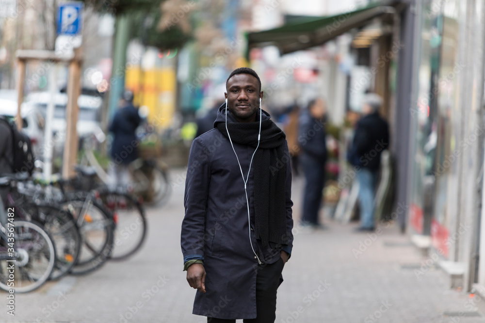 Handsome Black Man with Earphones Posing on Sidewalk Handsome Black Man with Earphones Posing on Sidewalk