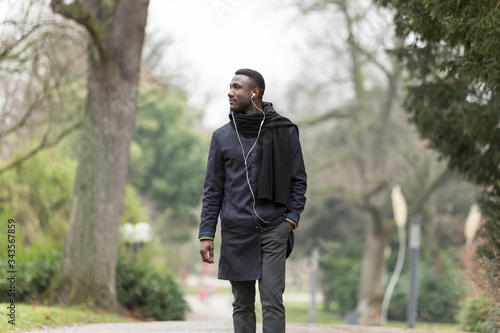 Well Dress Black Man with Hand in Pocket Walking in Park