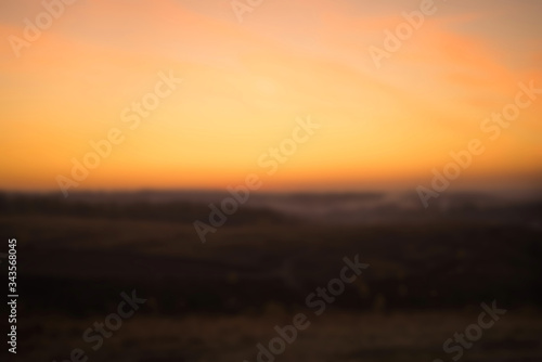 Blurred background of colorful orange sunset in the mountains. Romantic evening in the mountains. Love in the mountains. Countryside Landscape Under Scenic Colorful Sky At Sunset Dawn Sunrise. © Александра Вишнева