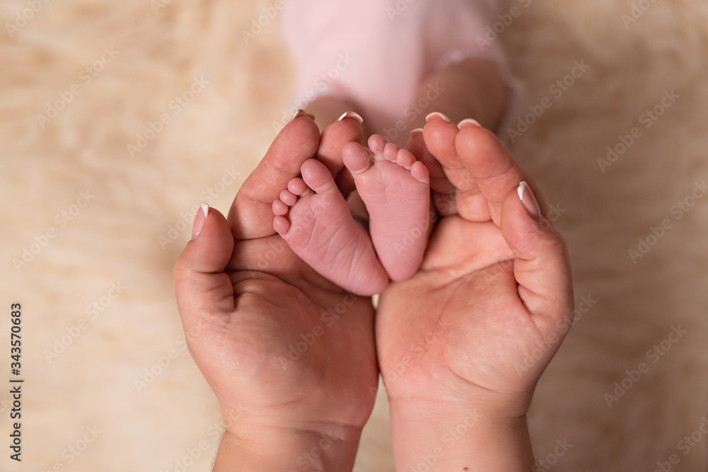 Baby feet in the arms of the mother. Mom and her child. The concept of a happy family. Baby feet in the arms of the mother. Mom and her child. The concept of a happy family.