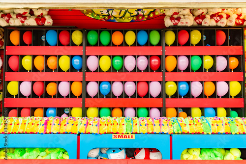 balloons and prizes at a dart throwing game booth at a carnival, fair, or amusement park