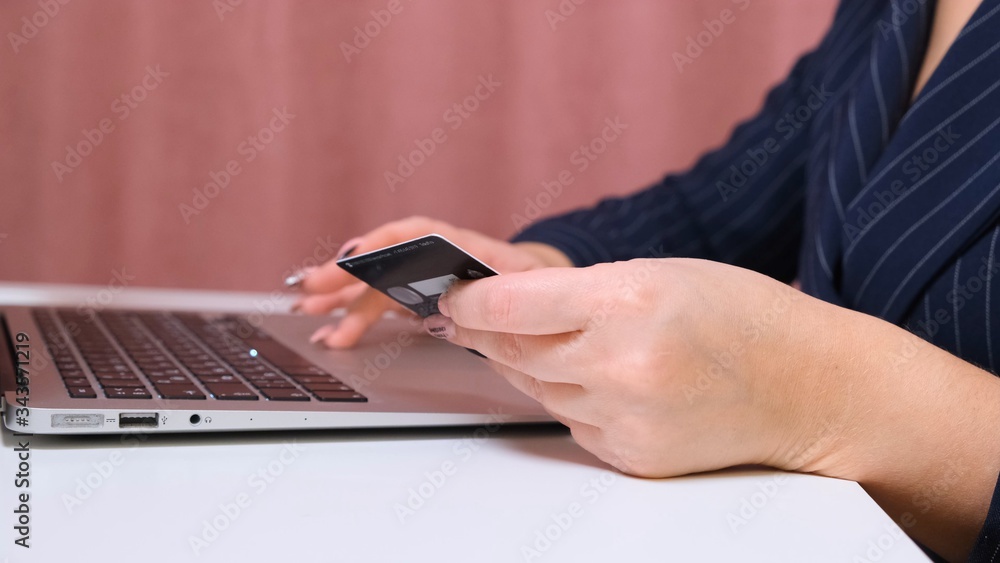 female hands make a purchase on the Internet using a laptop, payment by card, close-up. female hands make a purchase on the Internet using a laptop, payment by card, close-up.