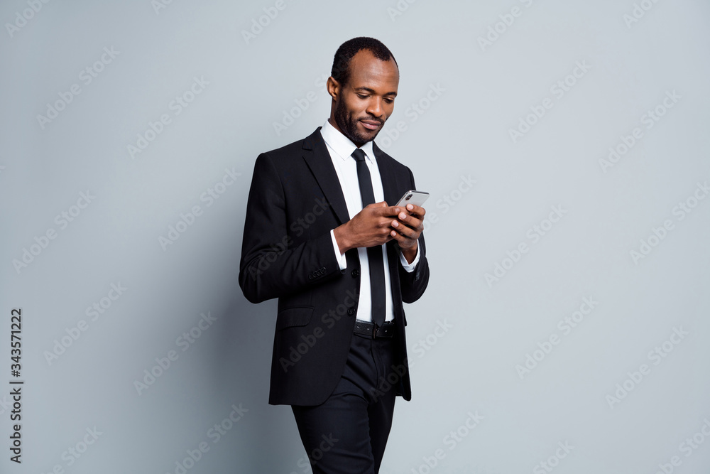 Portrait of his he nice attractive focused chic classy imposing guy employee banker holding in hands using device chatting planning meeting isolated over grey pastel color background Portrait of his he nice attractive focused chic classy imposing guy employee banker holding in hands using device chatting planning meeting isolated over grey pastel color background