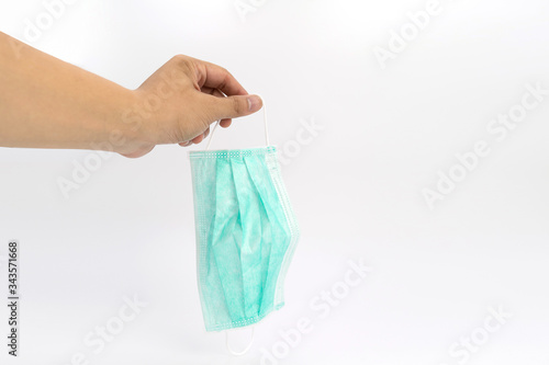 green new hygienic mask is held on Asian man hand in studio light on white background.