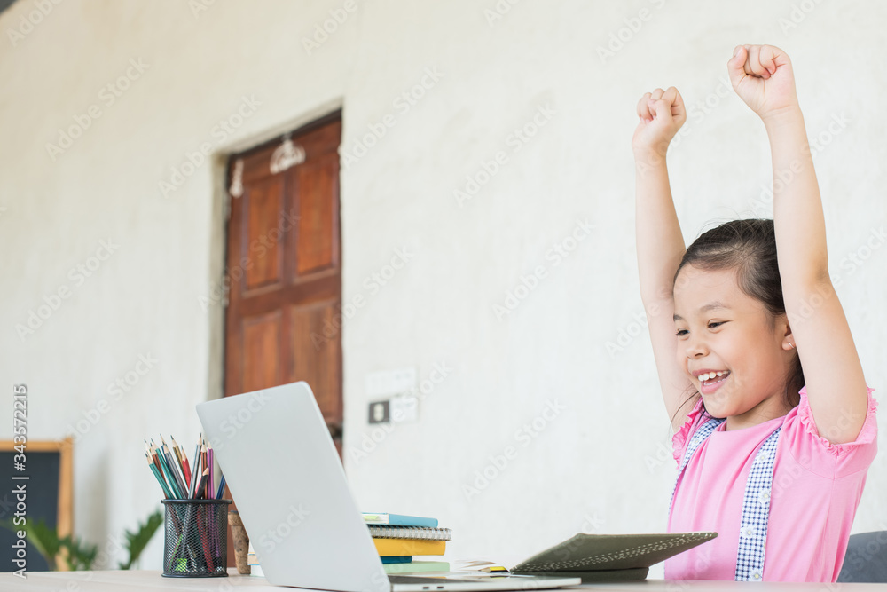 asian girl student online learning study online with video call teacher. social distance during quarantine, self-isolation, online education concept, homeschool, the child raised his hand to show joy. asian girl student online learning study online with video call teacher. social distance during quarantine, self-isolation, online education concept, homeschool, the child raised his hand to show joy.