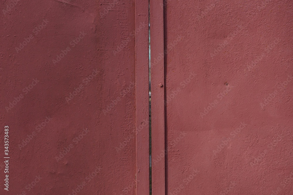 red metal texture from an old iron wall with a seam in the gate on the street red metal texture from an old iron wall with a seam in the gate on the street