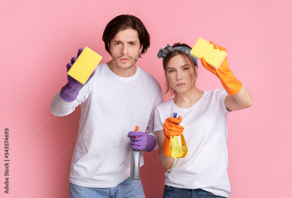 Neaty Couple Holding Sponges And Sprayers And Looking Suspiciosly At Camera