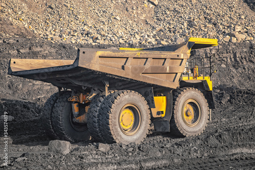 Big yellow mining truck laden anthracite moves open pit coal mine