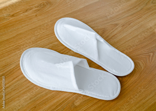 Couple new eco-friendly fabric disposable slippers lie on wooden floor