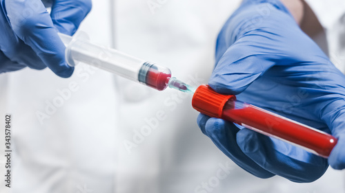 Doctor Drawing Blood Into Syringe in laboratory