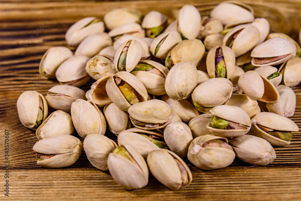 Pile of pistachio nuts on a wooden table