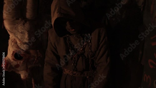 Silhouette of man maniac or killer or horror murderer with chainsaw in hand in dark creepy and spooky room. Criminal robber or rapist concept in thriller atmosphere with  victim girl