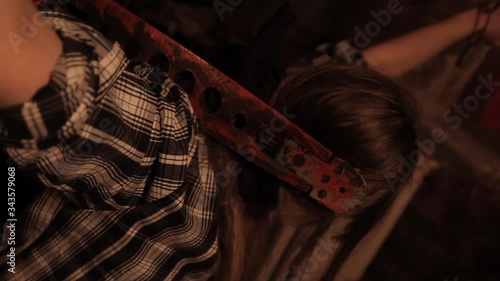 Silhouette of man maniac or killer or horror murderer with chainsaw in hand in dark creepy and spooky room. Criminal robber or rapist concept in thriller atmosphere with  victim girl