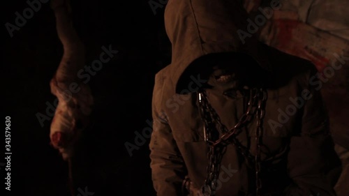 Silhouette of man maniac or killer or horror murderer with chainsaw in hand in dark creepy and spooky room. Criminal robber or rapist concept in thriller atmosphere with  victim girl
