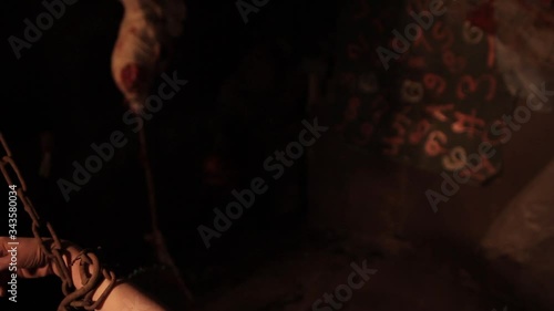 Silhouette of man maniac or killer or horror murderer with chainsaw in hand in dark creepy and spooky room. Criminal robber or rapist concept in thriller atmosphere with  victim girl