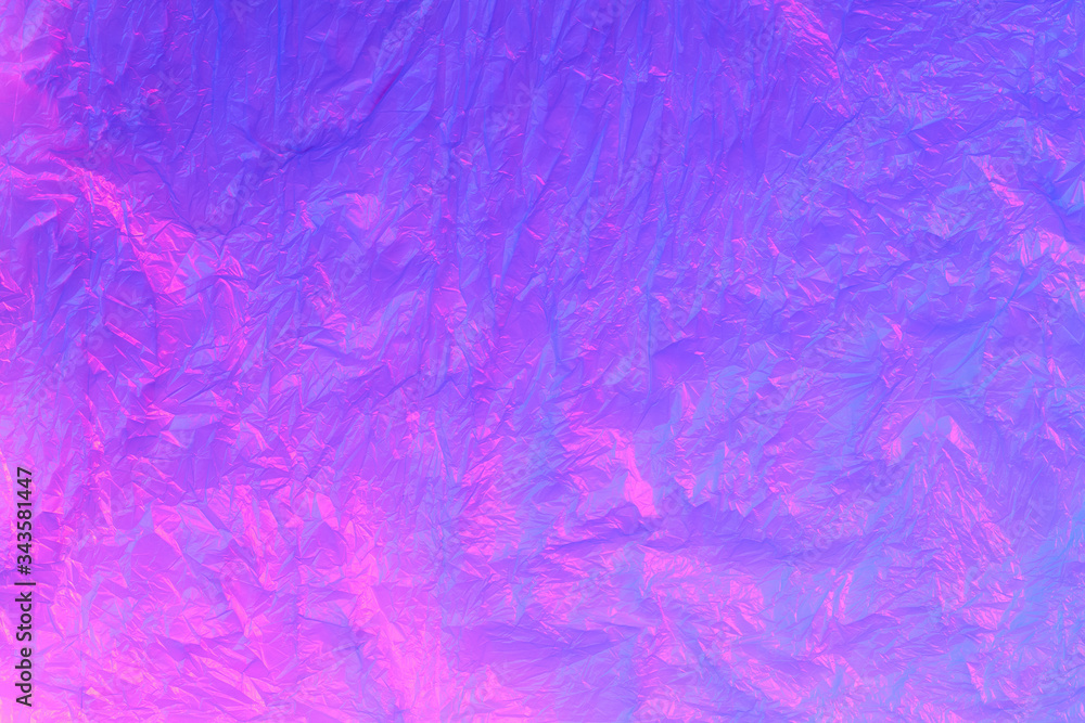 Background from purple recyclable polyethylene in neon pink light. Eco, zero waste, alternative to plastic concept. Flat lay. Horizontal. Closeup Background from purple recyclable polyethylene in neon pink light. Eco, zero waste, alternative to plastic concept. Flat lay. Horizontal. Closeup