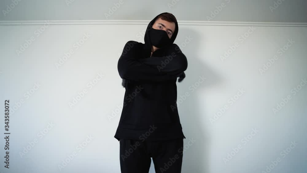 A young guy in black shows a welcome gesture in the form of a protruding thumb and little finger. White background A young guy in black shows a welcome gesture in the form of a protruding thumb and little finger. White background